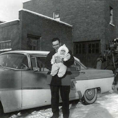 Photograph - Ron Sweezey holding son Patrick in front of a 1956 Chrysler