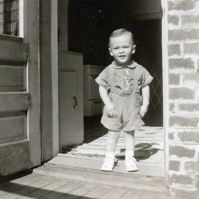 Photograph - Young Patrick Sweezey standing at the back door of his home above the Capreol fire hall