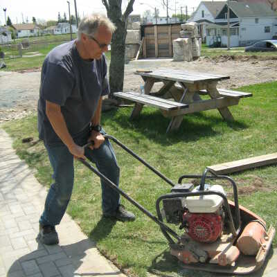 Photograph, NORMHC, Director Bob Michelutti packs walkways around Garden of Life.