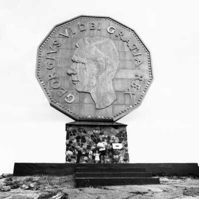 Photograph - Man and three children posing in front of the Big Nickel, Sudbury