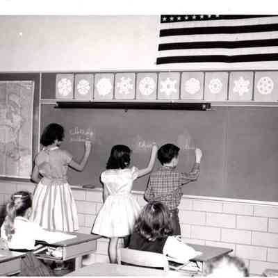 School Children writing on Board.