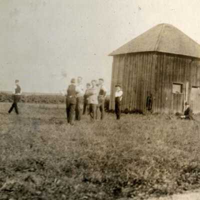 Young Men Near A Farm Shed