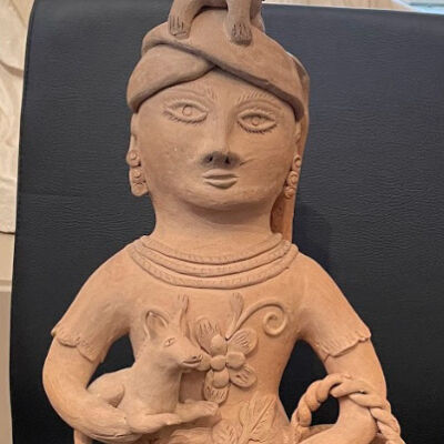 Figure of Mexican Woman Holding a dog with a cat on her head and basket with bird.
