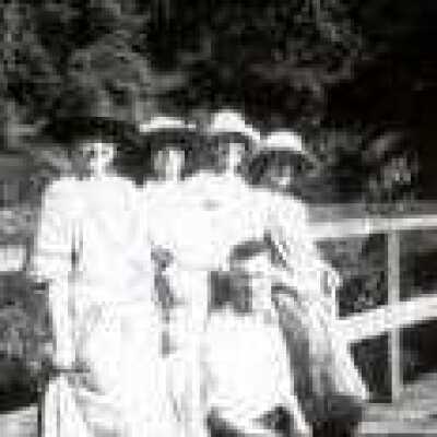 Four women and a man by fence