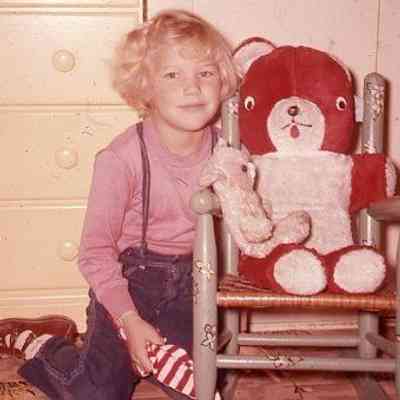 26. Nancy (Bailey) Conrad sitting in KJH's bedroom near stuffed animal: Zylstra House - Dec. 1958