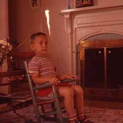 41. KJH sitting in chair by fireplace: Zylstra House - June 1957