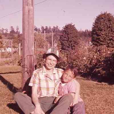 42. JJC (smiling) and KJH in backyard by clothesline pole. Pennington Hill in background: Zylstra House - ca. 1957