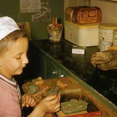 56. KJH playing with clay in kitchen: Monk House - April 1957