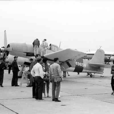 Visitors climb on and around plane at airshow.