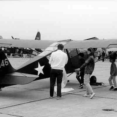 Visitors look at small historic plane.