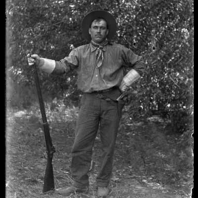 Man posing with rifle: Origsize: 4x5; Origformat: Negative