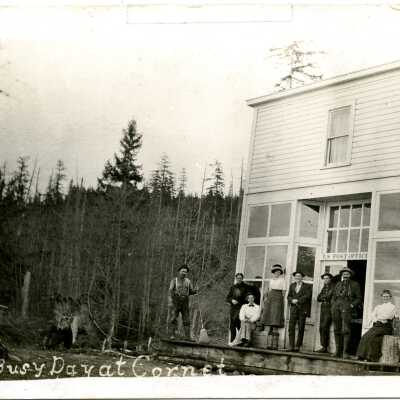 Post office and store at Cornet Bay. Owned by John Langs uncle. 9 people standing on porch.