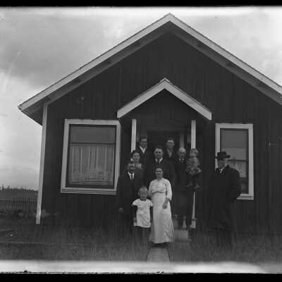 Family group outside house on front steps: Origsize: 4x5; Origformat: Negative