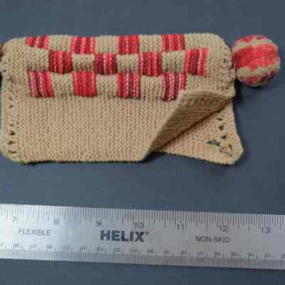 438 - tea pot cozy, knit tan, variegated red, tassels on end