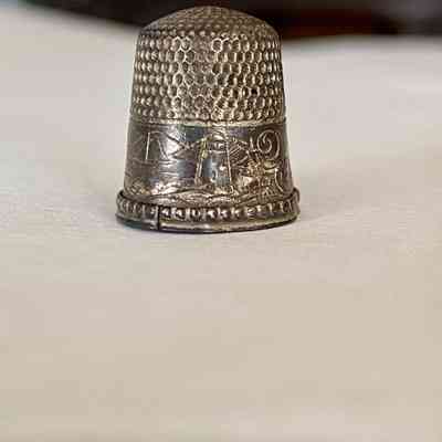 Lighthouse (center) and sailboat (left) engraving on thimble.