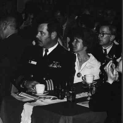 Men in Navy uniforms with wives.