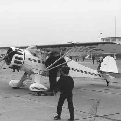 Visitors look into single engine plane with Explorer written on door.