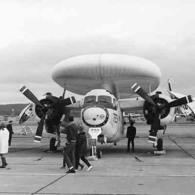 Navy plane with folded wings and large radar appendage.