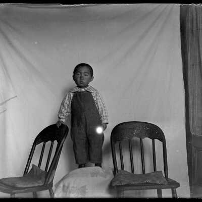 Little boy between two chairs: Origsize: 4x5; Origformat: Negative