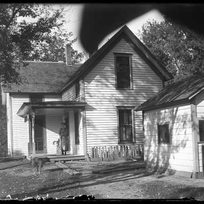 Woman on farmhouse porch: Origsize: 4x5; Origformat: Negative