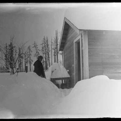 Snow scene, woman outside house: Origsize: 4x5; Origformat: Negative