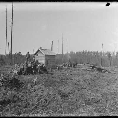 Men on log pile: Origsize: 4x5; Origformat: Negative