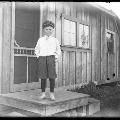 Boy outside screen door: Origsize: 4x5; Origformat: Negative