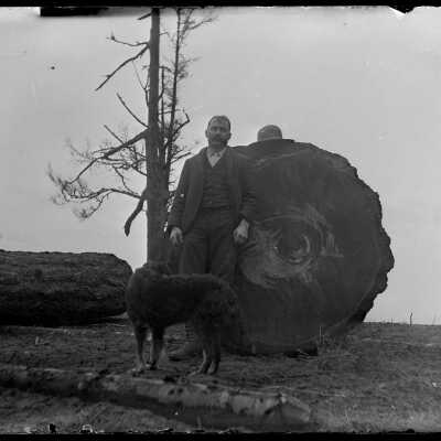 Man with dog by log in Coupeville City Park: Origsize: 4x5; Origformat: Negative