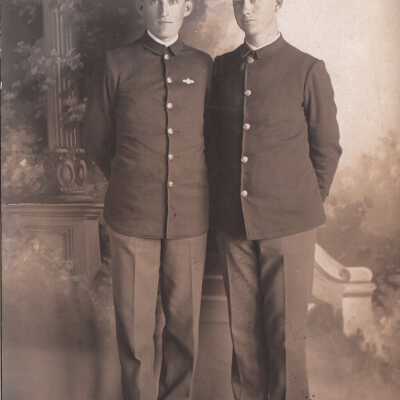 Two soldiers posing infront of decorative backdrop: Origsize: 3.5x5.5; Origformat: Print-Photographic
