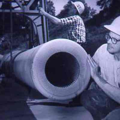 Worker Inspecting a Cannon