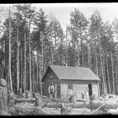 Couple outside cabin: Origsize: 4x5; Origformat: Negative