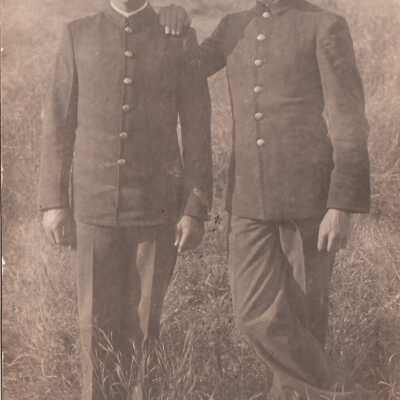 Two men posing together in grassy field: Origsize: 3.5x5.5; Origformat: Print-Photographic