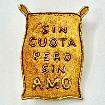 Political-slogan lapel pin — "Sin cuota pero sin amo" (sugar-sack form)