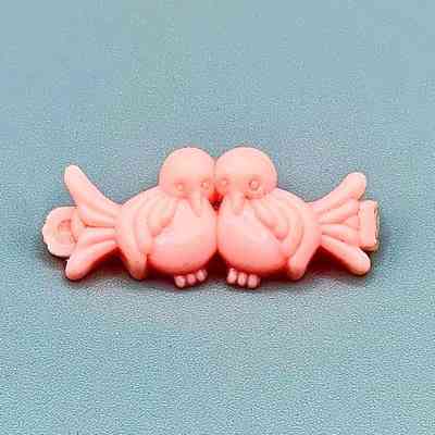 Molded-plastic toddler's hair barrette in the form of two birds