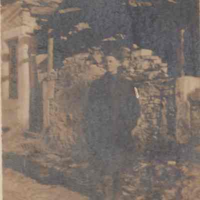 Solider in front of a wrecked house