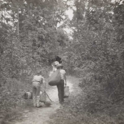 Boys carrying camping gear