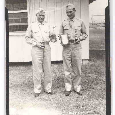 Two Officers Holding Trophies