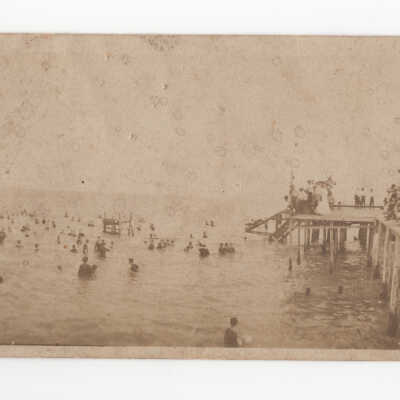 People swimming and on the pier