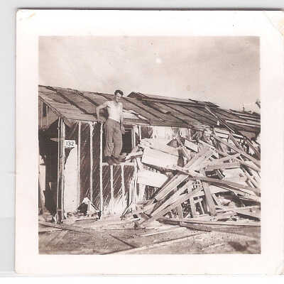 Men standing on damaged structure