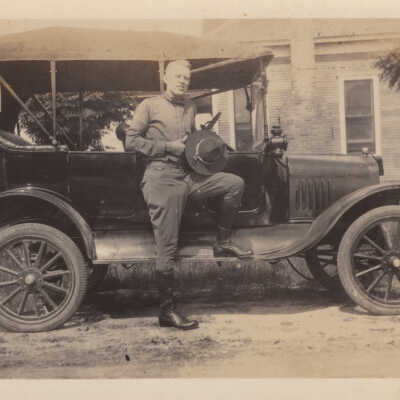 Unknown man leaning on car