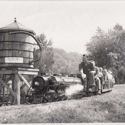 Thomas C Marshall, Jr, operating the #401 locomotive as it passes the water tower, 1960