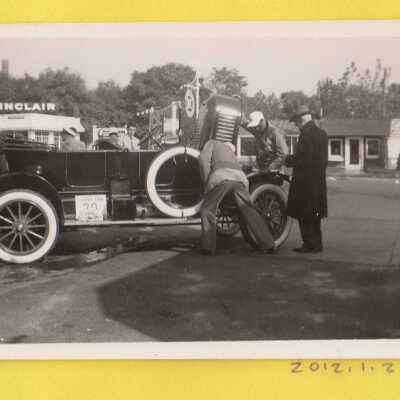 Three men looking under the hood on a Glidden Tour