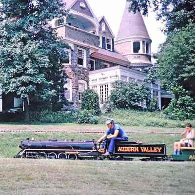 Engine 402 being operated by Larry Jensen in front of the mansion at Magic Age of Steam, 1973