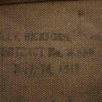 interior of 2024.1016.24.1: Heavily edited photo of the inside of the legging to bring out the faded stencil writing. First used in 1911 and not originally owned by William Hynes. Blacklight needed to get clearer reading.