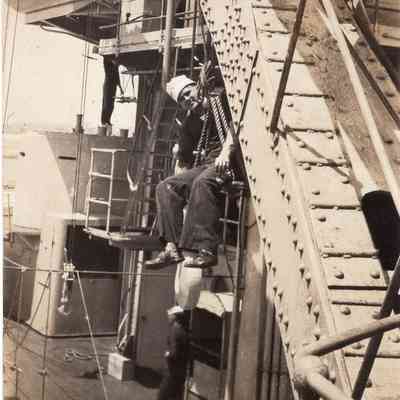 Sailor relaxes on crane