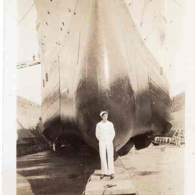 NY sailor stands in front of bow