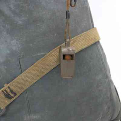 whistle (2024.1013.49.3) fastened to kapok life jacket (2024.1013.49.1)