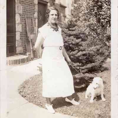 Woman and dog in front of house