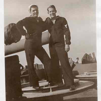 Two men pose by barrel
