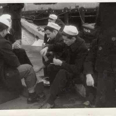 Sailors play cards on deck